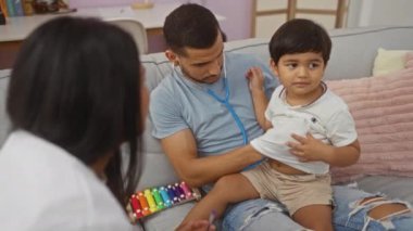 Doktor çocuğu muayene ederken erkekler onu rahat bir oturma odasında rahatlatıyor. Ailesini, sağlığını ve ev temalarını ön plana çıkarıyor.