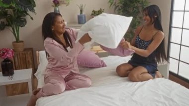 Yatak odasındaki bir yatakta yastık savaşı yapan kadınlar aile sevgisi ve bağlarını sergiliyor, ev içi eğlence ve neşe tasvir ediyorlar..