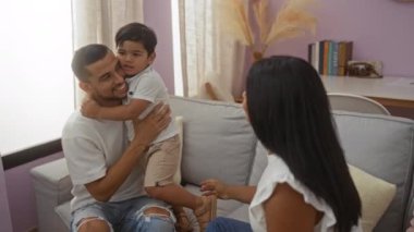 Genç bir aile, bir kadın rahat, sıcak bir iç mekanda etkileşim içindeyken, evde bir erkekle birlikte oturma odasında kaliteli zaman geçirir..