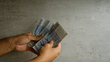 Koreli eller somut bir arkaplan karşısında para kazandı, mali işlemler ve para yönetimi vurgulandı.