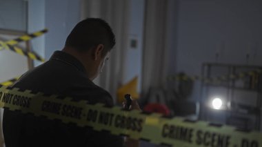 İspanyol bir adam, sarı polis bandı ve el feneriyle karanlık bir suç mahallini inceliyor..