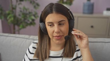 Kulaklık takan ve mikrofona konuşan genç bir kadın müşteri hizmetleri ya da uzaktan iletişim hissi verir..