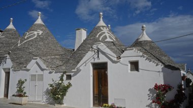 Trulli evleri alberobello, İtalya 'da, açık mavi gökyüzünün altında ikonik konik çatılar sergiliyor, bu büyüleyici puglia kasabasının eşsiz mimarisini temsil ediyor..