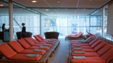 Lüks yolcu gemisindeki bulanık dinlenme odası. Kapalı alanda yürüyen bir kadın. Zarif bir bokeh etkisi altında, sofistike bir ortam ve konfor sergiliyor..