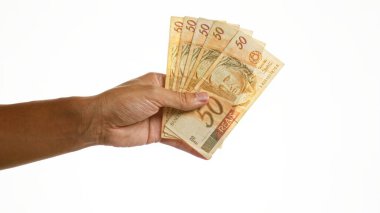 El ele tutuşan Brezilya 50 reais banknotları, beyaz arka planda izole edilmiş.