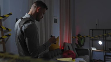 İspanyol adam modern apartman oturma odasındaki suç mahallini araştırıyor.