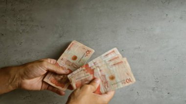 Kolombiya 'da para yönetimi kavramını vurgulayan somut bir arka planda Kolombiya pezosu sayan eller