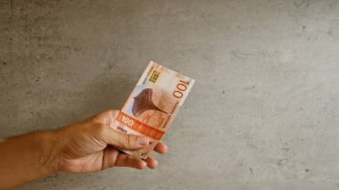 Norveç 'te döviz ve finans konularının vurgulanması ve somut bir arkaplan karşısında Norveç kronu banknotlarının el ele tutulması