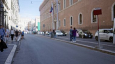Roma 'daki bulanık sokak manzarasında, tarihi binalarla eski bir kasaba yolunda yürüyen insanlar İtalya' daki dağılmış bir şehir atmosferini yakalıyor..
