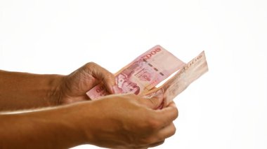 Tayland 'daki mali işlemleri gösteren beyaz arka plan duvarı üzerinde Tayland baht para biriminin el ele tutuşması.