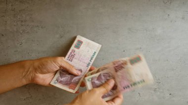 Elle tutulan Mısır sterlinli banknotlar beton arka planda, sergilenen para birimi Mısır 'da.