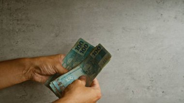 Brezilya 'nın gerçek banknotlarını tutan eller, Brezilya' daki finansal kavramları vurguluyor..