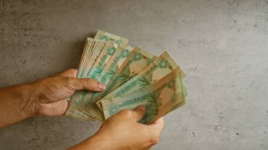 Birleşik Arap Emirlikleri 'ni elinde tutan adam, somut bir geçmişe karşı Dirham banknotlarını tutuyor ve para ve mali işleme odaklanıyor..