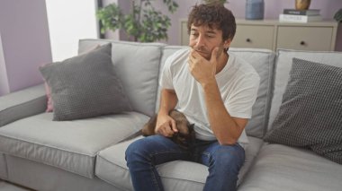 İspanyol bir adam evdeki bir kanepede kedi beslerken düşünüyor.