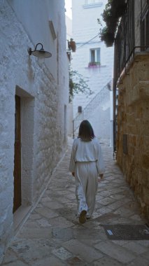 Genç İspanyol bir kadın polignano 'nun büyüleyici taş caddelerinde yürüyor. Puglia, İtalya' da bir kısrak. Avrupa mimarisinin resimlerini sergiliyor..