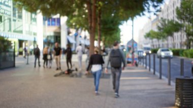 Marsilya, Fransa 'da odak dışı sokak manzarası. Odaklanamayan kentsel ortam, bulanık ağaçlar, bokeh efektleri ve belirsiz mimari ile dışarıda yürüyen insanları görüntülemek..