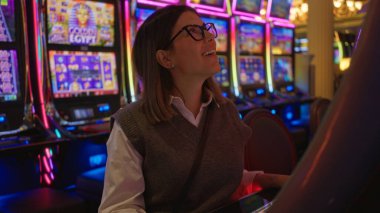 Canlı Las Vegas Kumarhanesi 'nde gülümseyen bir kadın. Etrafı renkli kumar makineleriyle çevrili. Lüks ve heyecan saçıyor..