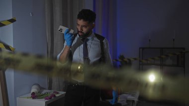 Sakallı İspanyol dedektif, gece olay yerinde dikkatli bir bant ve çiçeklerle, kapalı mekan gizemi konseptiyle akıllı telefonda konuşuyor..