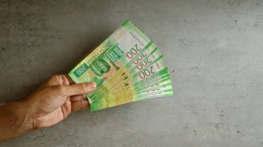 Somut bir arka planda Rus rublesi fanı tutan el ele tutuştuk.