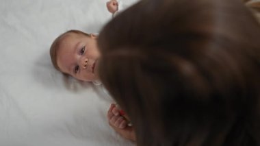 Anne ve bebek, sıcak bir evde sevgi dolu bir şekilde sevişiyorlar. Aile bağlarını ve bakımlarını ön plana çıkarıyorlar..