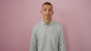 Genç adam, pembe arka planda elde ettiği başarıyı yumruklarını sıkarak ve neşeli bir gülümsemeyle kutluyor..