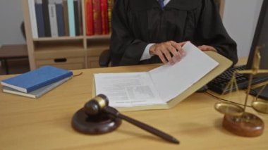 Mahkeme salonunda tokmak ve belgelerle çalışan siyah cübbeli bir yargıç, otoriteyi ve hukuki işlemleri vurguladı..