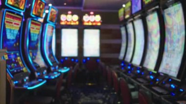 Las Vegas 'ın içindeki bulanık kumarhane. Renkli kumar makineleri, parlak ışıklar ve sıra sıra dizilmiş boş sandalyeler. Canlı, canlı bir atmosfer yaratıyor..
