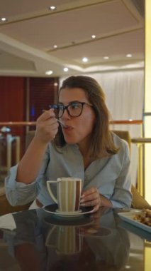 Kadınlar lüks bir barda kahvelerini içerken ortam aydınlatması, İspanyol, genç, bardaklar, yudumlama, yansıtıcı yüzey, lüks, rahatlama, rahatlama....