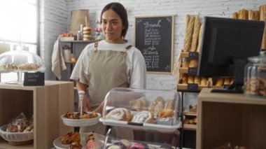 Kasanın yanındaki pastanede çalışan bir kadın, glütensiz yemek seçeneği sunuyor.