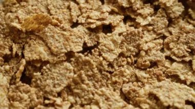 Mısır gevreğinin yakın plan çekimi, dokusunu ve kahverengi rengini vurgulamak, sağlıklı bir kahvaltı gevreği seçeneğini temsil etmek için mükemmel..