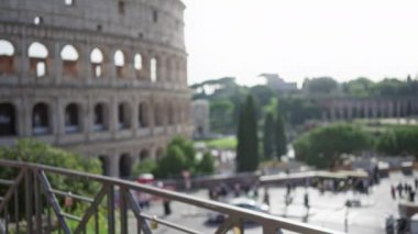 Bokeh etkisi altında yakalanan kolezyum, arka planda parlak bir İtalyan gökyüzünün altında hareketli turistlerin yer aldığı mimari ihtişamı vurguluyor..