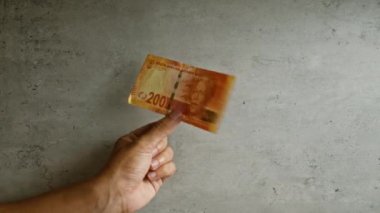 200 rands güney Afrika banknotu tutan adam beton bir arka planda