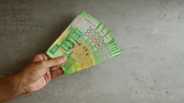 200 ruble 'lik Rus banknotlarını beton arka planda tutan bir el.