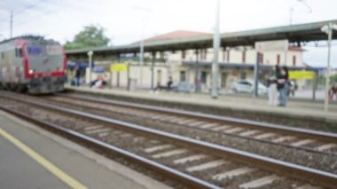 Bulanık tren arka planda bulanık insanlarla istasyondan geçiyor, trendeki graffiti şehir atmosferini, rayları ve platformu ekliyor hareket ve seyahat öneriyor.