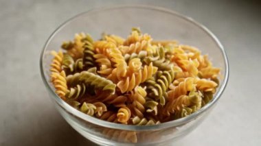 Mutfak tezgahına yerleştirilmiş temiz bir kasede çok renkli fusilli makarna.