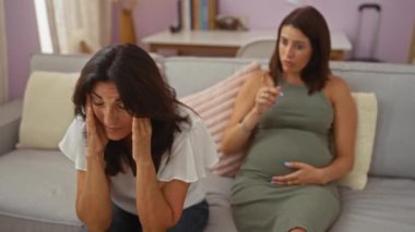 Anne ve hamile kız oturma odalarındaki koltukta duygularını tartışıyor ve hayal kırıklıklarını ve endişelerini dile getiriyorlar.
