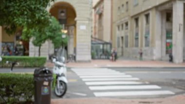 La spezia, İtalya 'da bulanık yayalar, scooter ve bina arkaplanı olan kentsel bir caddenin odaksız görüntüsü