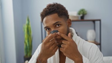 Kaplıcadaki yakışıklı genç adam rahat bir ambiyansı olan kapalı bir güzellik salonunda burnuna maske takıyor.