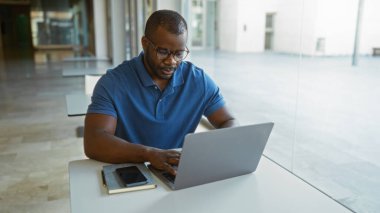 İş yerinde dizüstü bilgisayarla çalışan genç bir adam.