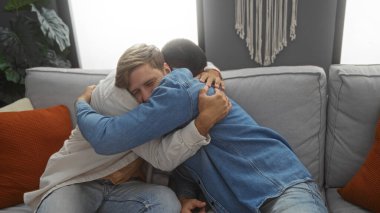 İki yakışıklı, sıcak bir apartman dairesinde kucaklaşıp samimi ve destekleyici bir dostluk sergiliyorlar..