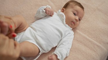 Sevimli yeni doğmuş bebek yatak odasında uzanmış sıcak bir evde sevimli çocukluk anları sergiliyor..