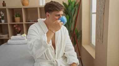 Yakışıklı bir adam sağlık merkezinde çay yudumluyor, beyaz bir bornoz giyiyor, bir salonda ya da kaplıcada rahatlık ve rahatlığı gösteriyor..