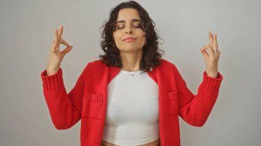 Kırmızı kazaklı çekici esmer kadın izole edilmiş beyaz bir arka plan üzerinde huzur içinde meditasyon yapıyor..