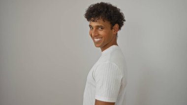 Beyaz gömlekli genç adam izole edilmiş beyaz arka plana bakıp gülümsüyor.