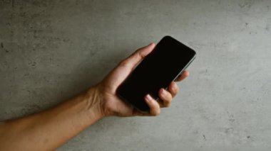 Akıllı telefonu arka planda tutan adam, teknolojiyi, iletişimi ve modern yaşam tarzını ön plana çıkarıyor.