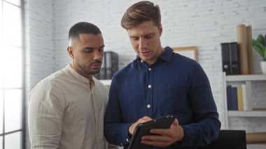 Modern bir ofiste çalışan adamlar, kapalı alanda bir tablet kullanarak projeyi tartışıyorlar.