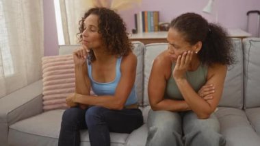 Oturma odasında birlikte oturan kadınlar, düşünceli yüz ifadeleriyle, güçlü bir bağ ve sıcak bir yuva ortamında duygularını paylaştılar..