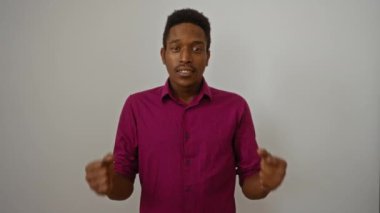 Genç adam, izole edilmiş beyaz arka plana karşı yumruklarıyla kutluyor. Güven ve neşe sergiliyor..