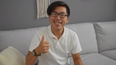 Oturma odasında oturan genç bir adam karışık duygular ifade ediyor.