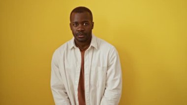 Adamım, Afro-Amerikalı, tişört giyiyor, İtalyan jesti ile ayakta duruyor; kendinden emin el ve parmaklar izole edilmiş sarı arka plan üzerinde ifade ediyor